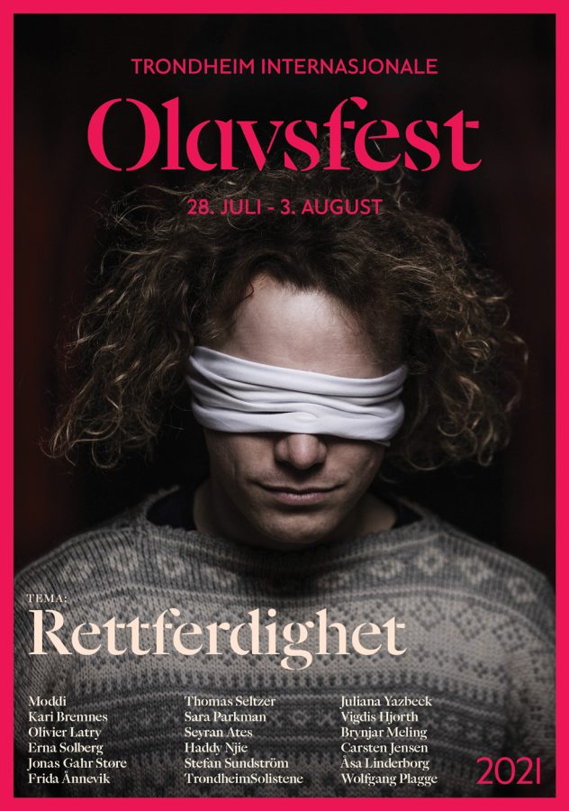 Forsiden på festivalavisa til Olavsfest som viser hovedtemaet Rettferdighet. En mann med langt hår og krøller med hvitt bind foran øynene som hovedbilde.